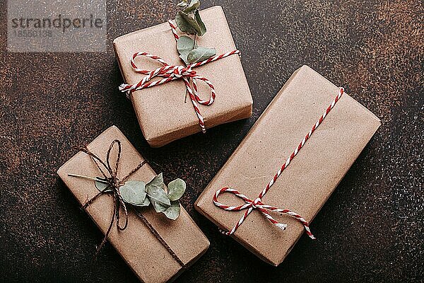 Minimalistische Weihnachtsgeschenke flach legen Zusammensetzung auf dunklen konkreten Hintergrund. Weihnachten und Neujahr elegante Geschenkboxen Draufsicht