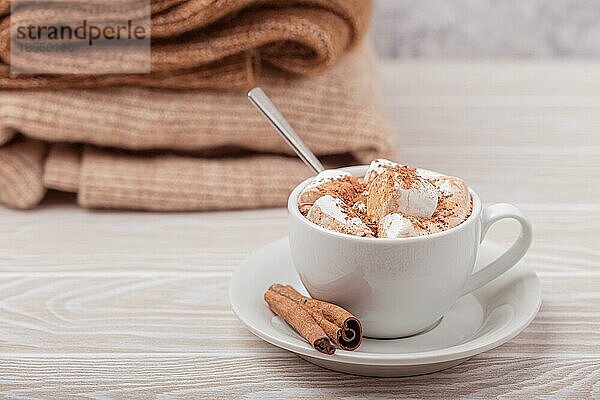 Cozy Winter Zusammensetzung  Tasse mit heißer Schokolade oder Kakao mit Marshmallow und Stapel von warmen gestrickte Kleidung auf weißem Holz rustikalen Hintergrund. Gemütliche und weiche Winter zu Hause  freier Raum für Text