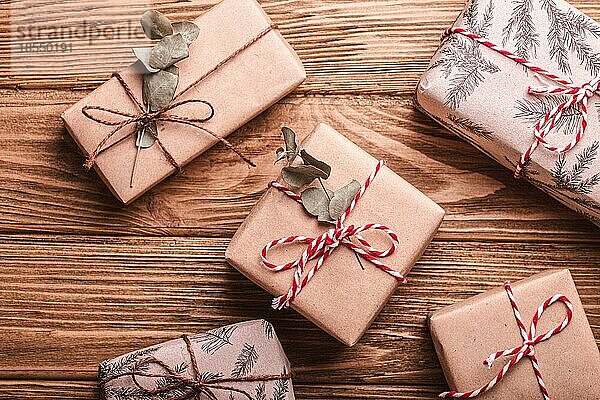 Minimalistische Weihnachtsgeschenke flach legen Zusammensetzung auf hölzernen rustikalen Hintergrund. Weihnachten und Neujahr elegante Geschenkboxen Draufsicht