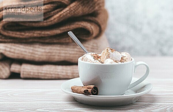 Cozy Winter Zusammensetzung  Tasse mit heißer Schokolade oder Kakao mit Marshmallow und Stapel von warmen gestrickte Kleidung auf weißem Holz rustikalen Hintergrund. Gemütliche und weiche Winter zu Hause  freier Raum für Text