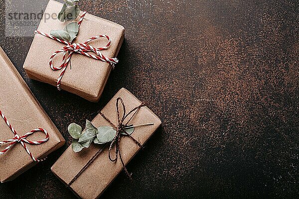 Minimalistische Weihnachtsgeschenke flach legen Zusammensetzung auf dunklen konkreten Hintergrund. Weihnachten und Neujahr elegante Geschenkboxen Draufsicht mit Freiraum für Textvorlage