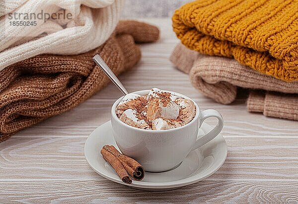 Cozy Winter Zusammensetzung  Tasse mit heißer Schokolade oder Kakao mit Marshmallow und Stapel von warmen gestrickte Kleidung auf weißem Holz rustikalen Hintergrund. Gemütliche und weiche Winter zu Hause  freier Raum für Text