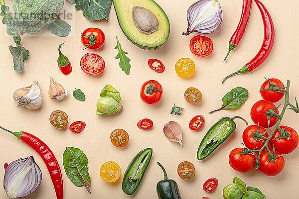 Kreative Kochen gesunde Bio-Lebensmittel-Konzept Hintergrund aus bunten Obst und Gemüse auf beige Hintergrund flach legen: Tomaten  Brokkoli  Avocado  Zwiebel  Knoblauch  Kräuter Draufsicht