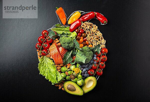 Gesunde Ernährung und Ernährung für Herz und Herz-Kreislauf-System  gesunde Lebensmittel  Obst und Gemüse Anordnung in realistischer Herzform auf schwarzer Kreidetafel Draufsicht flach legen Zusammensetzung