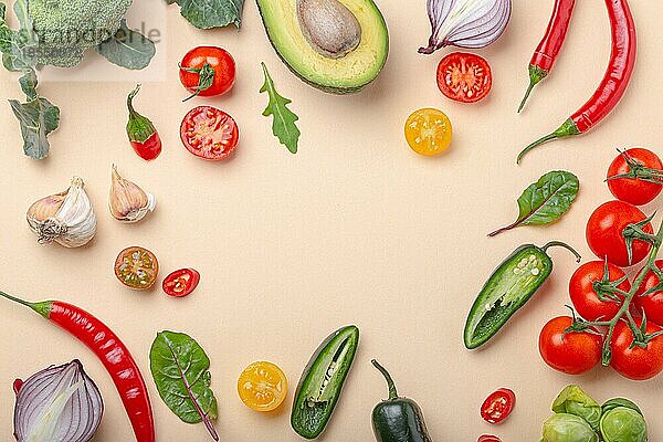 Kreative Kochen gesunde Bio-Lebensmittel-Konzept Hintergrund von bunten Obst und Gemüse auf beige Hintergrund flach legen: Tomaten  Brokkoli  Avocado  Zwiebel  Knoblauch Draufsicht mit Platz für Text