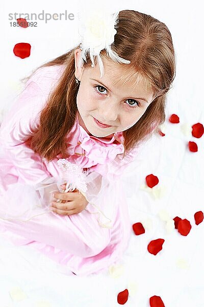 Nettes Mädchen gekleidet wie Prinzessin mit Rosenblättern