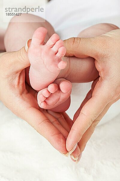 Mutter hält die Füße des Neugeborenen geringe Schärfentiefe