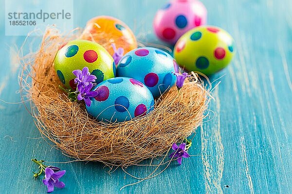 Bunte Ostereier mit Frühlingsblumen als Tischdekoration