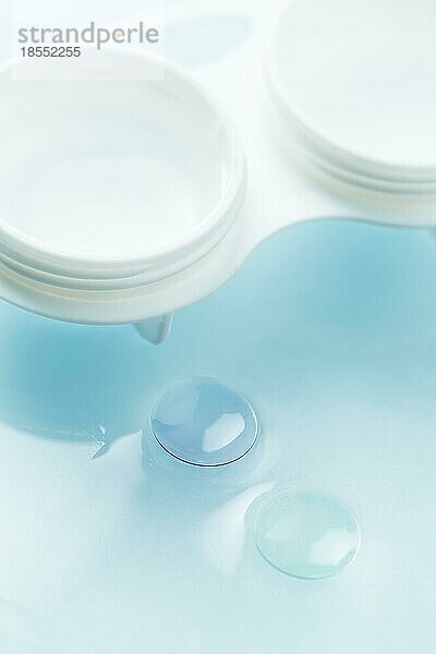 Makrodetail moderner starrer gasdurchlässiger Kontaktlinsen (GP) in Aufbewahrungslösung und Aufbewahrungsbehälter
