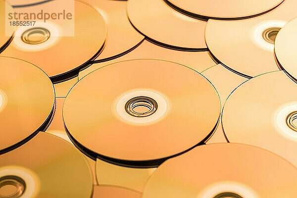 CDs und DVDs in Goldtönen als Hintergrund. Weichzeichner