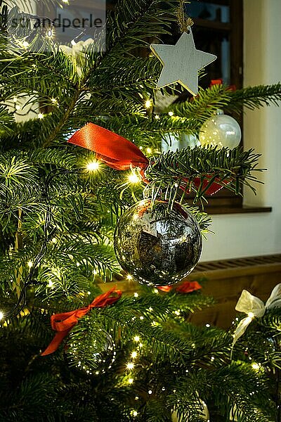 Nahaufnahme einer Weihnachtskugel  die an einem geschmückten Weihnachtsbaum hängt