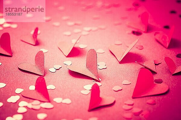 Rote Papierherzen auf rotem Hintergrund als Hintergrund. Konzept der Liebe und Valentinstag