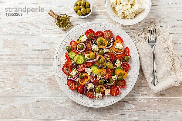 Griechischer Salat aus frischen Gurken  Tomaten  Paprika  Kopfsalat  roten Zwiebeln  Fetakäse und Oliven mit Olivenöl Dressing. Gesundes Essen  Ansicht von oben
