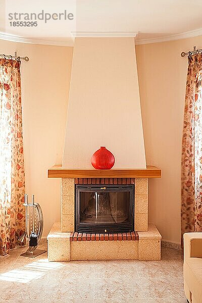 Konzept des Kamins mit Feuer zu Hause. Gemütliches Wohnzimmer im mediterranen Stil