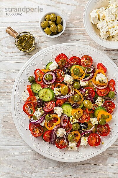 Griechischer Salat aus frischen Gurken  Tomaten  Paprika  Kopfsalat  roten Zwiebeln  Fetakäse und Oliven mit Olivenöl Dressing. Gesundes Essen  Ansicht von oben