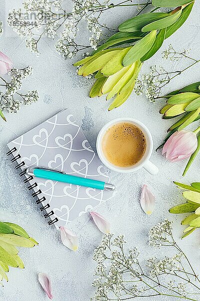 Arbeitsbereich mit Tagebuch  Notizbuch  Stift  Blumen auf hellblauem Hintergrund. Schreibtisch im Heimbüro. Top view femininen Hintergrund. Flachlage  Draufsicht