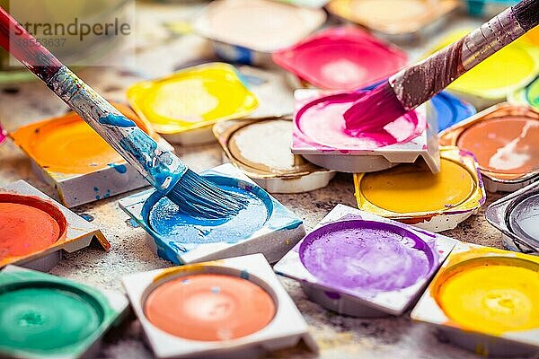 Set mit bunten Aquarellfarben und Pinseln für die Malerei aus nächster Nähe. Selektiver Fokus