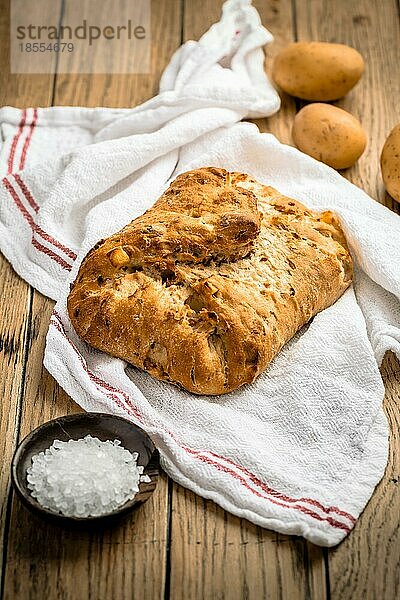 Kartoffelbrot mit Dinkelmehl und gerösteten Zwiebeln auf Holztisch