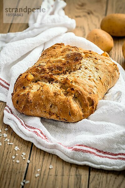 Kartoffelbrot mit Dinkelmehl und gerösteten Zwiebeln auf Holztisch