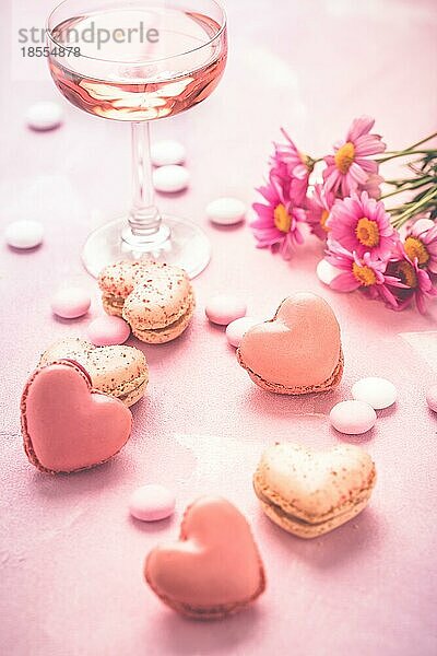 Happy Mothers Day süße Macarons und ein Glas Rosensekt mit Blumen in Rosatönen