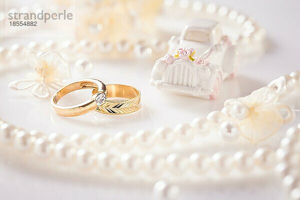 HochzeitsStillleben mit goldenen Ringen und Perlenkette in Weiß