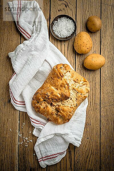 Kartoffelbrot mit Dinkelmehl und gerösteten Zwiebeln auf Holztisch