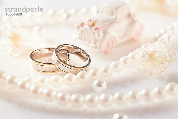 HochzeitsStillleben mit goldenen Ringen und Perlenkette in Weiß