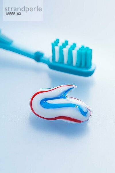 Bunte Zahnpasta und Zahnbürste auf blauem Hintergrund  Konzept der Zahnpflege und Hygiene