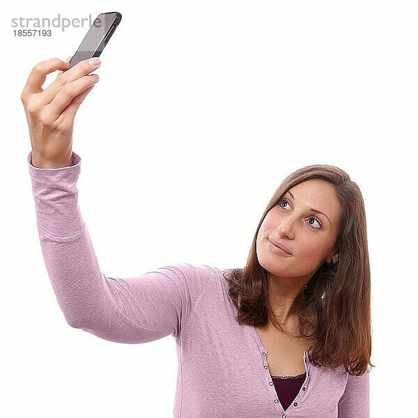 Junge Frau  die ein Selbstporträt mit ihrem Smartphone aufnimmt