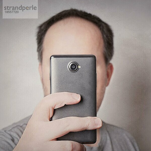 Mann  der mit der Smartphone-Kamera ein Selfie macht  das aussieht wie ein Zyklop mit Filter