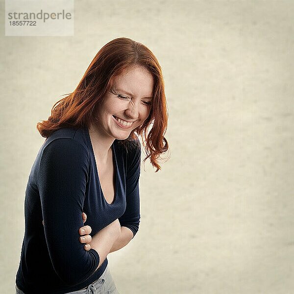 Junge Frau lachend mit texturiertem Hintergrund mit Kopierraum