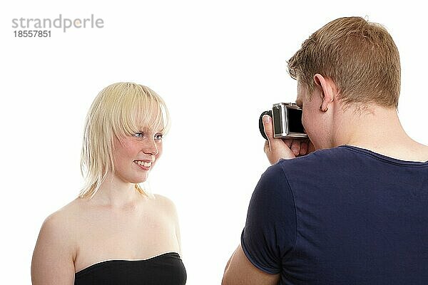 Kerl mit Fotokamera  der ein Bild von seiner hübschen blonden Freundin macht