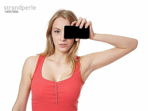 Junge Frau hält Smartphone-Kamera mit leerem Bildschirm vor dem Auge