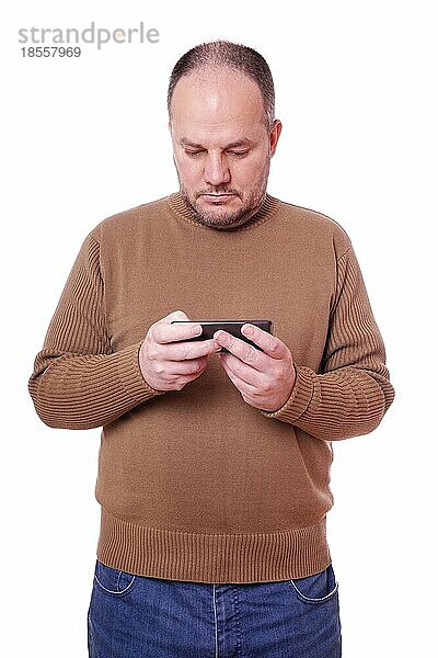 Mann mittleren Alters schaut auf sein Smartphone