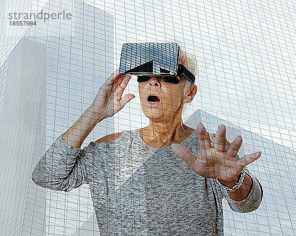 Ältere Frau mit Virtual-Reality-Headset ist von der VR-Erfahrung überwältigt