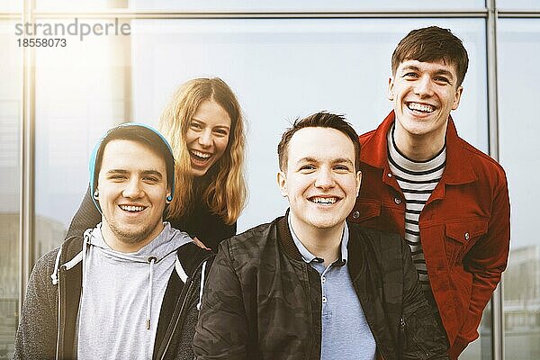 Gruppe von vier jungen Freunden im Teenageralter  die Spaß haben und zusammen lachen  Lifestyle-Porträt im Freien mit Sonneneinstrahlung