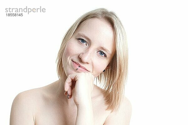 Porträt einer blauäugigen blonden jungen Frau mit blasser Haut aus Deutschland vor weißem Hintergrund