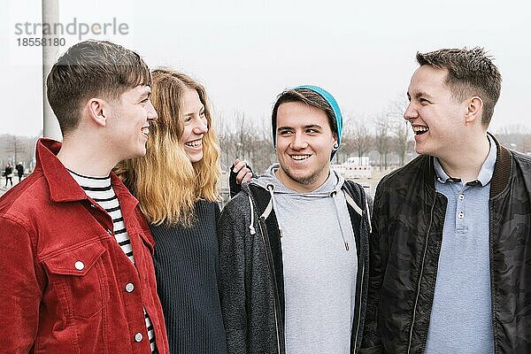 Eine Gruppe von vier jungen Freunden im Teenageralter  die miteinander reden und lachen  offene  echte Menschen
