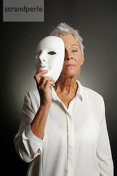 Ernst blickende reife Frau  die ihr wahres Gesicht hinter der Maske zeigt