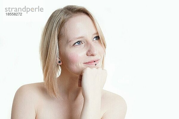 Porträt einer blauäugigen blonden jungen Frau mit blasser Haut aus Deutschland  die in den Kopierraum schaut