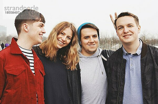 Gruppe von vier jungen Freunden im Teenageralter  die Arm in Arm posieren - lustiges Porträt mit Häschenohren