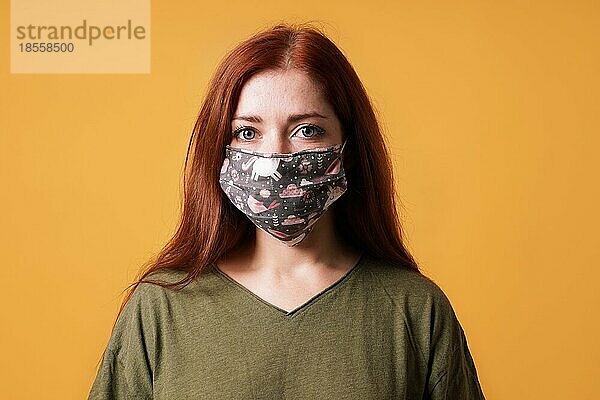 Junge Frau trägt eine selbstgemachte Gesichtsmaske aus Stoff oder eine Gemeinschaftsmaske - Covid-19-Coronavirus-Pandemie-Hygiene-Konzept