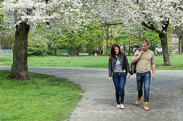 Junges Paar  das im Frühling durch einen Park spaziert