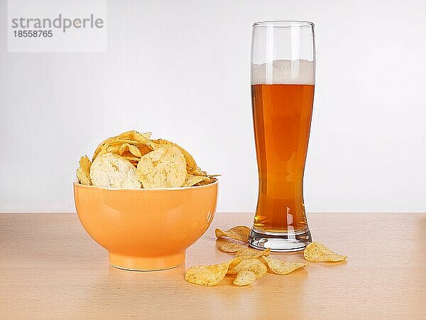Eine Schale Kartoffelchips oder Chips und ein Glas Weizenbier
