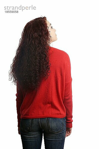 Rücken- oder Rückansicht einer lässigen jungen Frau  vor weißem Hintergrund  die nach oben schaut