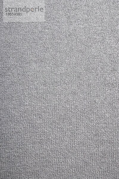 Grauer gestrickter Hintergrund  Nahaufnahme eines grauen Strickpullovers