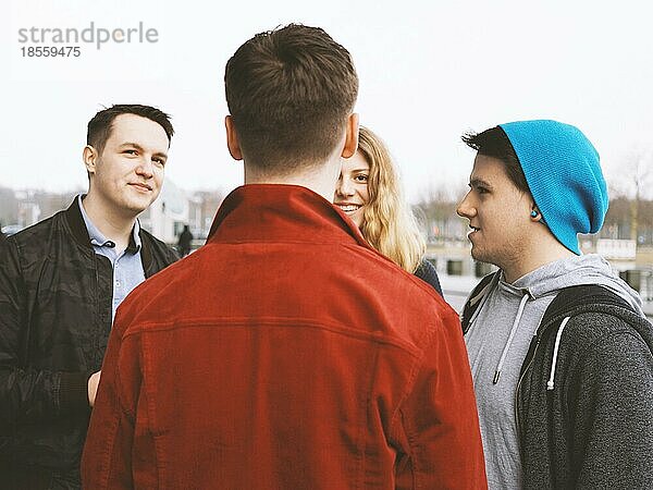 Gruppe von vier jungen Freunden im Teenageralter  die miteinander reden und lachen  ehrliche  echte Menschen  gefiltertes Bild