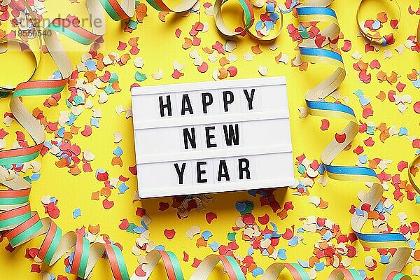 Frohes neues Jahr Party Feier flach legen mit Konfetti und Luftschlangen auf gelbem Hintergrund
