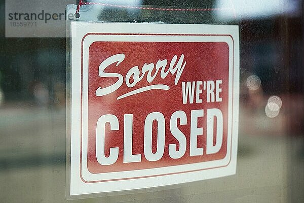 Sorry we're closed-Schild hinter der schmutzigen Glastür während der Schließung von Corona