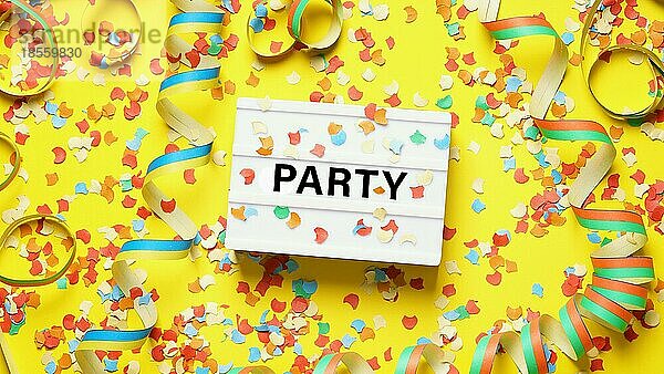 Party Feier Flat-Lay mit Konfetti Luftschlangen und Text auf Lichtkasten